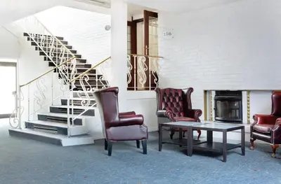 a living room with chairs and a table and a staircase at Comfort Hotel Fosna in Kristiansund