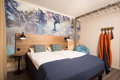 a bedroom with a bed and a painting on the wall at Scandic Hafjell in Hafjell