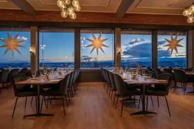 a dining room with tables and chairs and large windows at Beito Resort Hotel in Beitostøl