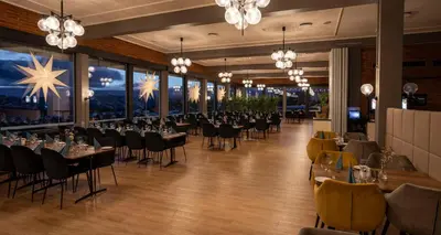 a dining room with tables and chairs and chandeliers at Beito Resort Hotel in Beitostøl