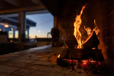 a fire burns in a stone fireplace at Beito Resort Hotel in Beitostøl