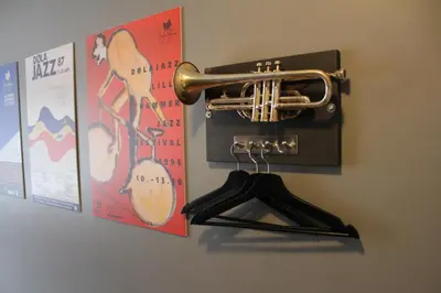 a brass trumpet hanging on a wall with posters at Stasjonen Hotel in Lillehammer