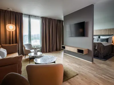 a living room with a couch and a bed at Quality Airport Hotel Værnes in Stjoerdal