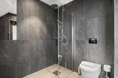 a bathroom with a glass shower with a toilet at Clarion Hotel Admiral in Bergen