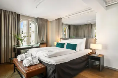 a bedroom with a large bed and a desk at Clarion Hotel Admiral in Bergen