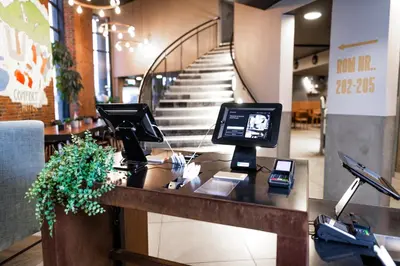 a lobby with a desk with a computer and a staircase at Comfort Hotel Bergen in Bergen