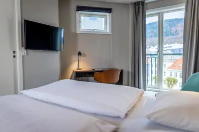a hotel room with a bed and a desk and a window at Comfort Hotel Bergen in Bergen