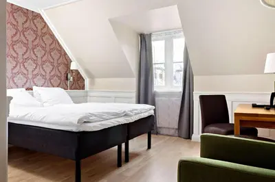 a bedroom with a bed and a desk and a chair at Best Western Plus Hotel Bakeriet in Trondheim