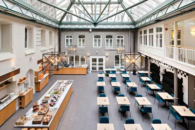 a cafeteria with tables and chairs in a building at Best Western Plus Hotel Bakeriet in Trondheim