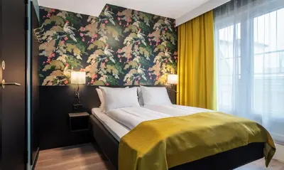 a bedroom with a large bed with a floral wallpaper at Thon Hotel Bristol, Bergen in Bergen