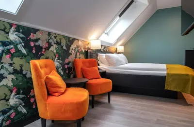 a hotel room with a bed and two chairs at Thon Hotel Bristol, Bergen in Bergen