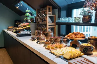 a buffet with cheese and other foods on a counter at Thon Hotel Bristol, Bergen in Bergen