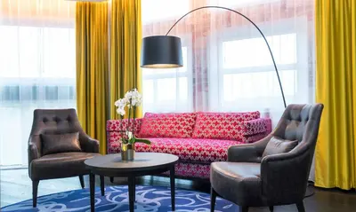 a living room with a red couch and two chairs at Thon Hotel Bergen Airport in Bergen