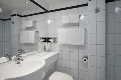 a white bathroom with a sink and a toilet at Thon Hotel Moldefjord in Molde