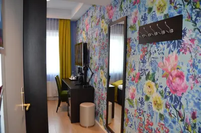 a room with a desk with a mirror and flowers on the wall at Thon Hotel Moldefjord in Molde