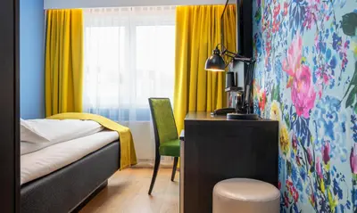 a bedroom with a bed and a desk and a window at Thon Hotel Moldefjord in Molde