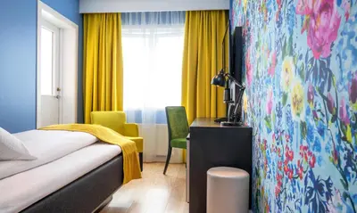 a bedroom with a bed and a desk and a window at Thon Hotel Moldefjord in Molde