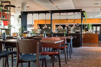 a restaurant with tables and chairs and a bar at Clarion Hotel Bergen Airport in Bergen