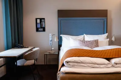 a bedroom with a large bed with a desk and a bed sidx sidx at Clarion Hotel Bergen Airport in Bergen