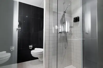 a bathroom with a toilet and a glass shower at Clarion Hotel Bergen Airport in Bergen