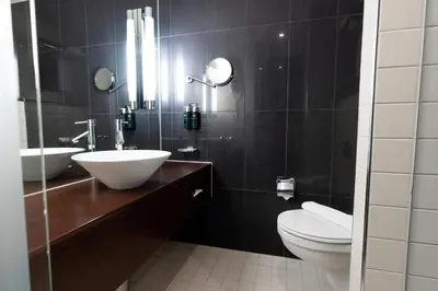 a bathroom with a sink and a toilet and a mirror at Clarion Hotel Bergen Airport in Bergen