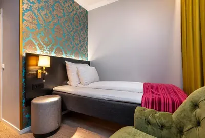 a small room with a bed and a chair at Thon Hotel Rosenkrantz Bergen in Bergen