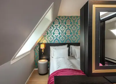 a bedroom with a bed and a staircase with a mirror at Thon Hotel Rosenkrantz Bergen in Bergen