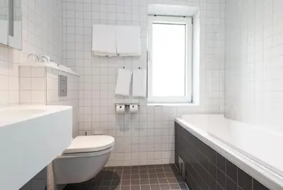a bathroom with a toilet and a tub and a sink at Thon Hotel Rosenkrantz Bergen in Bergen