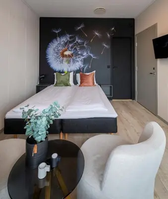 a bedroom with a bed and a table and a chair at Vikingskipet Hotell in Hamar