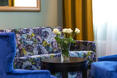 a living room with a couch and a vase of flowers on a table at Thon Hotel Orion in Bergen