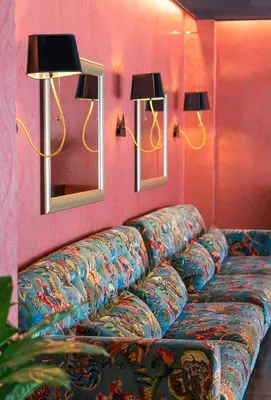 a couch in a room with two lights and two mirrors at Thon Hotel Orion in Bergen