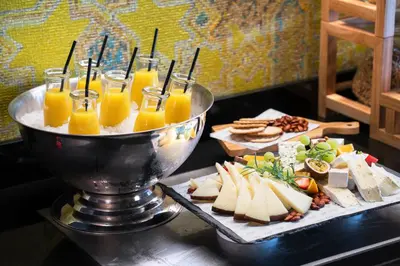 a table with a tray of cheese and orange juice at Thon Hotel Orion in Bergen