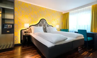 a bedroom with a large bed and a yellow wall at Thon Hotel Orion in Bergen