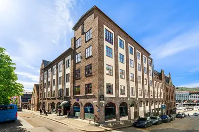 a large brick building on the corner of a street at Home Hotel Bryggen in Bergen
