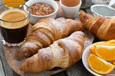 a wooden table with a plate of pastries and orange slices at Herangtunet Mountain Lodge in Heggenes