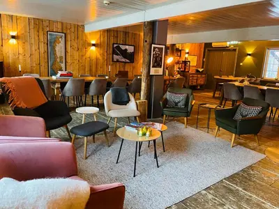 a lobby with chairs and tables and a bar at Herangtunet Mountain Lodge in Heggenes