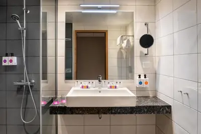 a white bathroom with a sink and a shower at Quality Hotel Sogndal in Sogndal