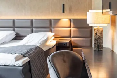 a bedroom with a desk and a bed and a chair at Quality Hotel Sogndal in Sogndal