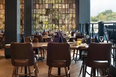a restaurant with wooden tables and chairs and windows at Quality Hotel Sogndal in Sogndal