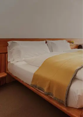 a bed with white sheets and a yellow blanket on it at Quality Hotel Sogndal in Sogndal