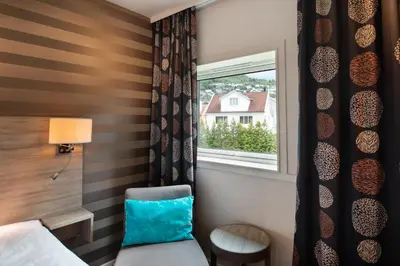a bedroom with a chair and a window at Quality Hotel Sogndal in Sogndal