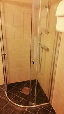 a shower with a glass door in a bathroom at Chesterfield Hotel in Trondheim