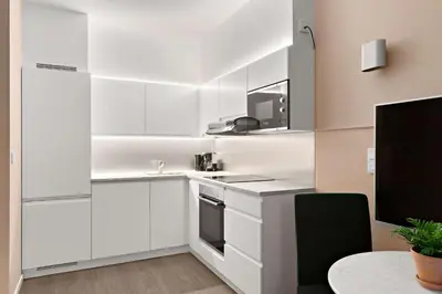 a white kitchen with a sink and a microwave at Ole Bull, Best Western Signature Collection in Bergen