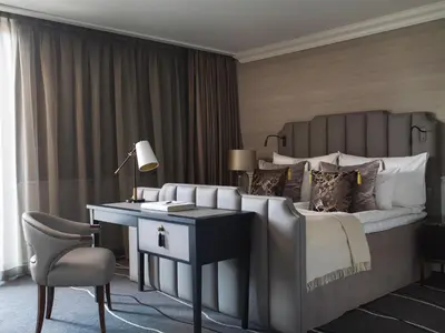 a bedroom with a large bed with a desk and a chair at Britannia Hotel in Trondheim