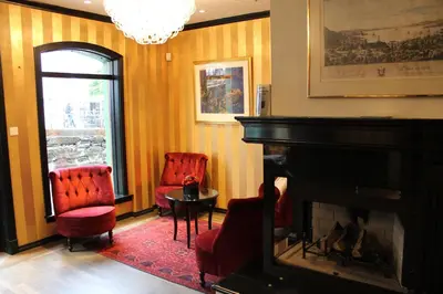 a living room with two chairs and a fireplace at Det Hanseatiske Hotel in Bergen