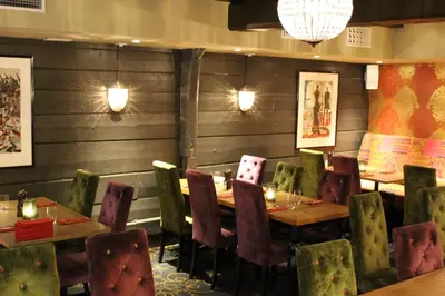 a restaurant with wooden walls and tables and chairs at Det Hanseatiske Hotel in Bergen