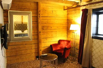 a room with a chair and a mirror and a bed at Det Hanseatiske Hotel in Bergen