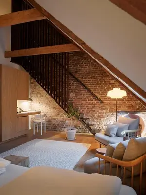 a living room with a staircase and a brick wall at Hotel 1904 in Ålesund