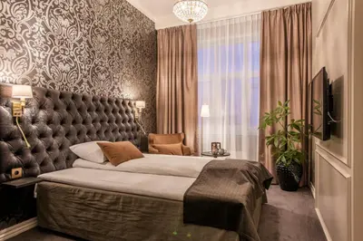 a bedroom with a large bed and a large window at Home Hotel Grand Gjøvik in Gjøvik