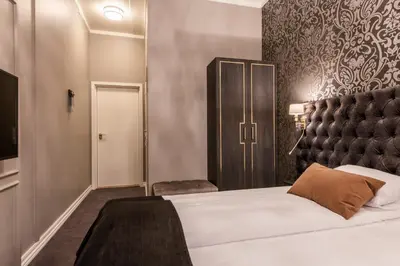 a bedroom with a large bed with a black headboard at Home Hotel Grand Gjøvik in Gjøvik